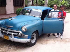 Eddie Moody with a taxi driver and his classic car, one of the pre-1960's vehicles the island is known for.