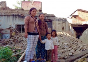 One of the girls in the Empower Nepali Girls program, standing with her family in front of what used to be her home. They are now living in a tent.