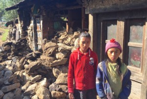 Two Empower Nepali Girls scholarship children stand in front of their damaged house near Lukla in the Mount Everest region of Nepal.