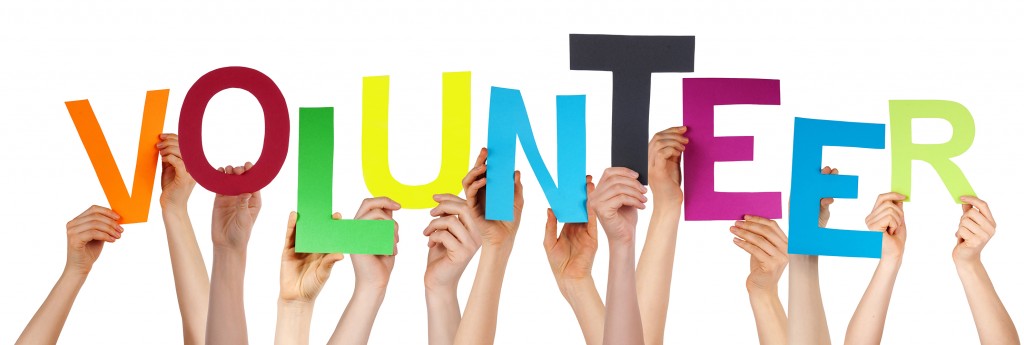 People Hands Holding Colorful Word Volunteer