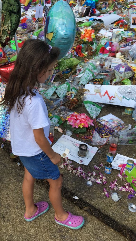 Lucia Lassiter-Sanabria, the author's 7 year-old daughter, at a memorial site set up recently at the Dr. Phillips Center for the Performing Arts in downtown Orlando. "I had been talking to Lucia about the [Pulse] shooting and wanted to show the enormous amount of love and support that was given. It was a tender moment watching her walk around and look at the pictures of the victims and reading some of the signs of love," says Sanabria.