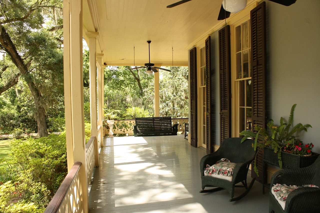 front porch of house with a a green chair and swing